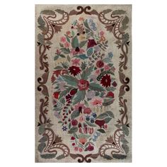 an antique rug with flowers and leaves on the border, in various shades of red