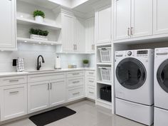 a kitchen with white cabinets and washer and dryer in the center, next to an oven