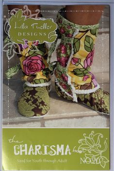 a pair of boots with flowers on them sitting on top of a tile floor in front of a sign