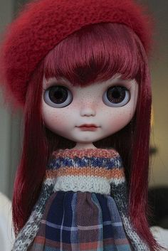 a close up of a doll with red hair