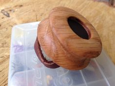 a wooden object sitting on top of a plastic container