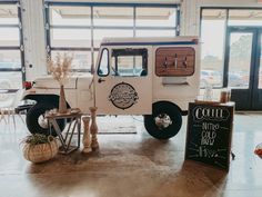 an old white truck is parked in a building with chalkboard signs on the wall