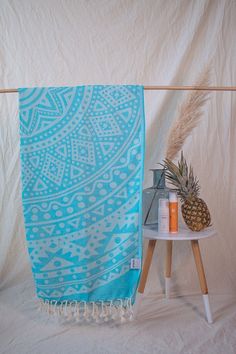 a blue and white towel sitting on top of a table next to a pineapple