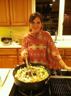 a woman cooking food in a skillet on top of the stove with a spatula