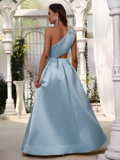 a woman in a blue dress is looking back at the camera while standing on a walkway