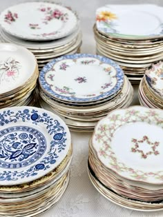 many plates are stacked on top of each other in different colors and designs, all with flowers