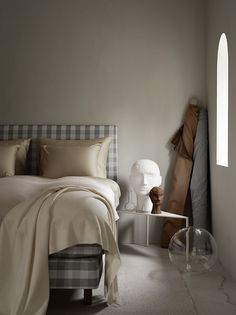 a bed sitting in a bedroom next to a window with an arched window sill