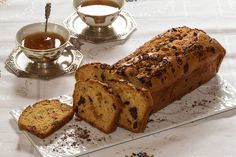 a loaf of bread sitting on top of a plate next to a cup of tea