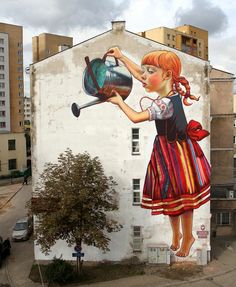 a painting on the side of a building with a girl pouring water into a pot