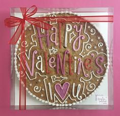 a cookie with the words happy valentine's day written on it in pink and white