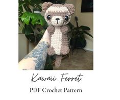 a crocheted teddy bear is posed in front of a plant with the words kawaia ferrett on it