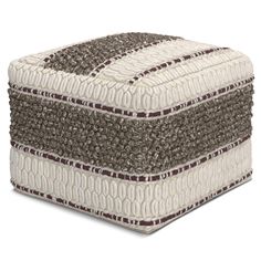 a white and brown ottoman sitting on top of a floor