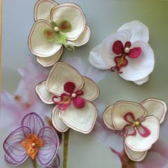 four paper flowers are sitting on a table