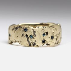 Made by Sophie, this rock ring is made from recycled gold and set with a subtle scatter of seven blue topaz across the front. This ring is 8mm wide and a UK size L1/2. It is handmade and ready to send. Dimensions: Width: 8mm Depth: 1.8 - 2.3mm Finish: Matte Stones: 7x 1.25mm topaz  Please don't hesitate to get in touch if you have any questions about this piece or ideas for a commission. We are always happy to hear from you! Note: this piece is also live on our website on Off the Benchpeg. In th Rock Ring, Rock Rings, Gold Topaz, Ring Blue, Recycled Gold, Precious Gems, Blue Topaz Ring, Blue Rings, Rings Statement