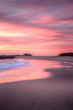 a pink and purple sunset at the beach