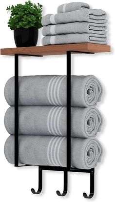 a shelf with towels and a potted plant on it