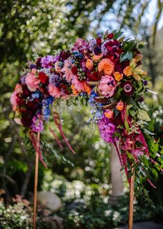 an arch decorated with colorful flowers and greenery