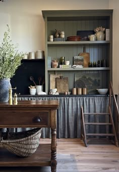 a kitchen with wooden floors and shelves filled with dishes