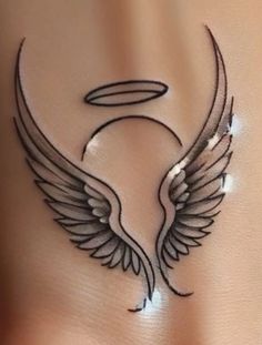 an artistic tattoo design on the side of a woman's stomach, with angel wings