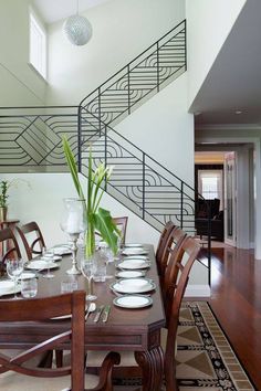 the dining room table is set with place settings for six people and has a staircase leading up to the second floor