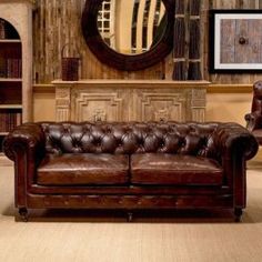 a brown leather couch sitting in front of a mirror