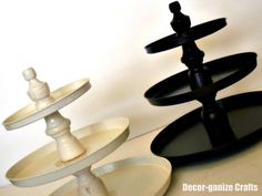 three black and white trays stacked on top of each other in the shape of an upside down cake stand