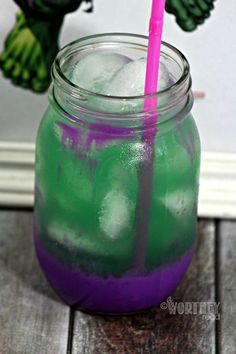 a purple and green drink in a mason jar with a pink straw sticking out of it