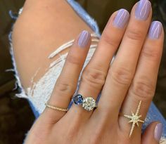 a woman's hand with two rings on it and one ring has a starfish