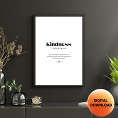 a black and white poster with the words kindness on it in front of a shelf