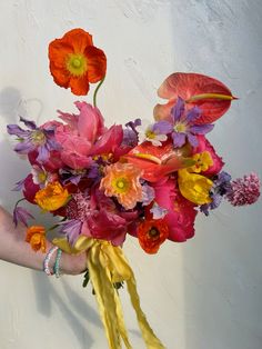 a person holding a bouquet of flowers in their hand