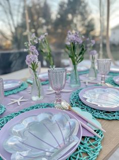 the table is set with purple and white dishes