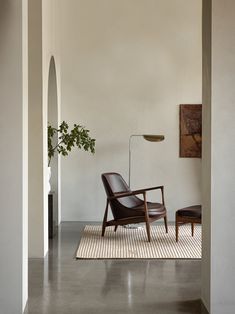 an empty room with a chair and plant in it