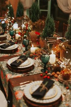 a table set for christmas dinner with place settings