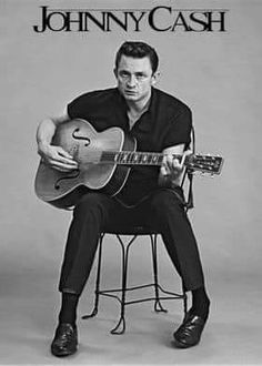 johnny cash is sitting on a stool with his guitar in front of him and the cover of his album