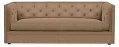 a tan couch with buttons on the back and arm rests against a white background,