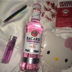 a hello kitty bottle next to a pen and some other items on a white sheet