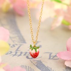 Infuse your style with the delightful charm of the Strawberry Necklace, an exquisite piece that captures the essence of nature's sweetness. This enchanting necklace features a beautifully crafted strawberry pendant, adorned with vibrant enamel detailing that brings the fruit to life in vivid color. Made from durable brass and lavishly coated in 18K gold, the necklace radiates luxury and ensures lasting quality. The strawberry, a symbol of love and happiness, adds a whimsical yet sophisticated to Dainty Enamel Necklace As A Gift, Valentine's Day Gift Enamel Charm Necklaces, Valentine's Day Gift Enamel Charm Necklace, Valentine's Day Enamel Pendant Necklace, Sweet Strawberry Print Jewelry As Gift, Cute Enamel Necklaces For Gifts, Delicate Enamel Jewelry For Gifts, Delicate Enamel Jewelry Gift, Sweet Jewelry With Fruit Design For Gift