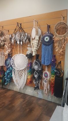 there are many dream catchers hanging up on the wall in this room with wood flooring