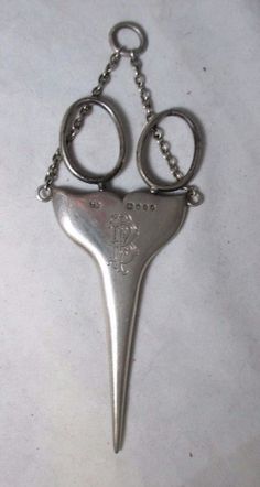 a metal key chain with two scissors on it