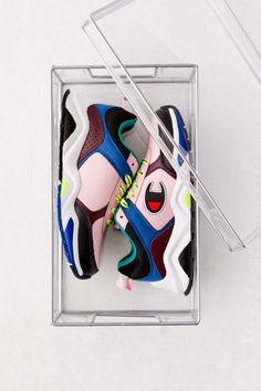 two pairs of sneakers in a clear box