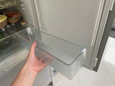 a hand reaching for something in the refrigerator