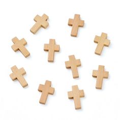 wooden crosses are arranged on a white surface