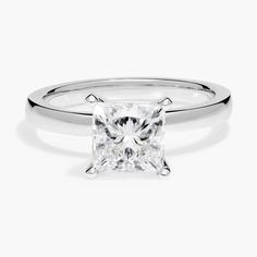 a white gold ring with a princess cut diamond