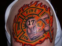 a man with a fire department tattoo on his arm holding an ax and wrench