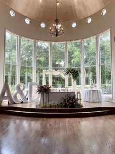 the inside of a wedding venue with large letters and flowers in front of it on a wooden floor