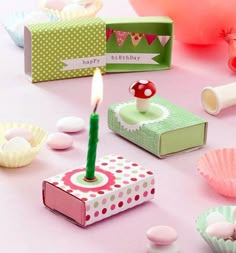 a birthday candle is lit in the middle of some cupcakes and other items