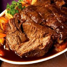 steak and carrots on a plate with gravy