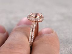 a close up of a person's hand holding a ring with a diamond on it