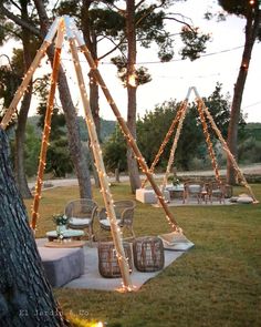 an outdoor seating area with lights strung from the trees