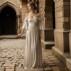 a woman in a white dress is standing on a brick walkway and looking off into the distance